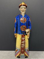 Front view of the tall Chinese porcelain statue showing detailed painting and attire.