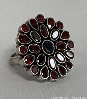 Front view of the garnet ring showing multiple oval and teardrop shaped red garnet stones in a flower cluster pattern on a silver setting.