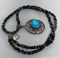 Necklace coiled showing pendant and beaded chain details.