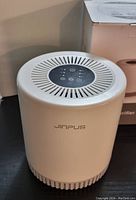 Jinpus air purifier unit showing top view with control panel and front brand name.