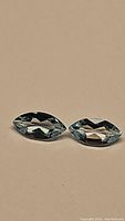 Pair of sky blue marquis cut topaz gemstones on beige background showing color and clarity