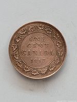 Reverse side showing denomination ONE CENT CANADA 1917 surrounded by maple leaf wreath.