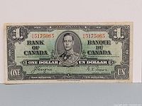 Front view of 1937 Bank of Canada one dollar banknote showing King George VI portrait and red serial number HN 5175065.