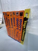 Side view of spines of seven 'Complete Idiot's Guide' books and one 'Yoga for Dummies' book, showing titles and colors.