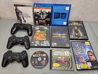 Full lot view showing games and three controllers on a table surface