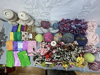 Overall view of the lot showing wool yarn balls, crochet thread, fabric pieces, and embroidery floss