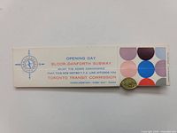 Paper holder with colorful geometric print and text about subway opening and TTC token.