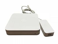 Front and side view of Apple AirPort A1408 wireless router in white plastic casing with Apple logo on top, paired with the rectangular power adapter and attached cables.