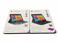 Two new open box Logitech Ultrathin Keyboard Folio keyboard cases for Samsung Galaxy Tab4 10.1, shown in original packaging with front view of box displaying tablet and keyboard images.
