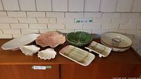 Wide shot of all serving ware items arranged on wooden surface against white brick wall.