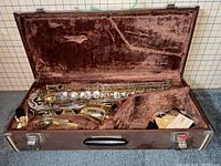 Saxophone in open hard shell case with accessories
