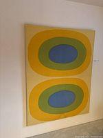 Front view of large fabric art with two concentric oval patterns.