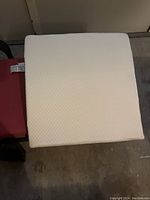 Top view of the white textured bed pillow wedge placed on a red chair.