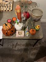 Full view of assortment on table including pumpkins, glasses, candles, and other decorative pieces