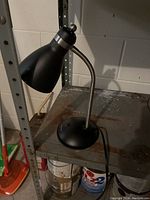 Photo of a modern black desk lamp with flexible gooseneck and round base.