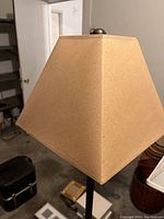 Close-up of the beige fabric lampshade showing its square tapered shape
