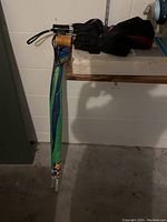 Photo showing four umbrellas including one with colorful pattern in green cover and three mostly black umbrellas with different types of handles.