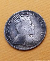 Obverse side showing King Edward VII profile with inscription 'EDWARDVS VII D G REX IMPERATOR'. Coin surface shows aging and wear.