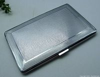 Closed view of rectangular Sylva Emu chrome cigarette case with textured surface and smooth border edges.