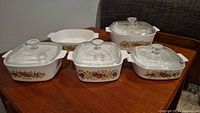 All five casserole and baking dishes with four glass lids displayed on tabletop
