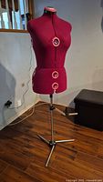 Front view of deep pink adjustable dress form on tripod base
