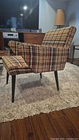 Front three-quarter view of the plaid lounge chair