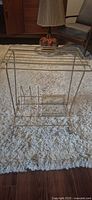 Full view of gold tone wire side table with rack