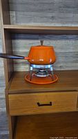 Complete fondue set on wooden shelf