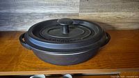 Braiser with lid on shelf showing overall form