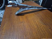 Side profile of chrome ram hood ornament on wood surface