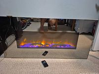 Fireplace with purple flame effect and remote shown