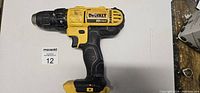 Left side of used cordless DeWalt 20V Max drill driver showing model labeling and ergonomic grip.