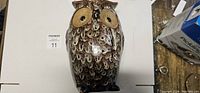 Front view of the owl shaped ceramic vase showing detailed feather texture and large eyes.