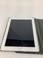 Front view of white Apple iPad inside flip case, screen off and home button visible
