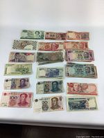 Full layout of foreign currency notes showing all notes in a flat arrangement on white surface, various colors and designs visible