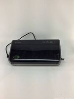 Top view of black FoodSaver vacuum sealer showing power cord and button layout.