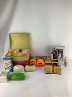 Photo showing all skin care and personal health items arranged on white background, including Guerlain gift set, soaps, creams, dental mouthguard, and stress balls.