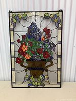 Front view of the rectangular stained glass panel showing floral design, frame and suspension hooks