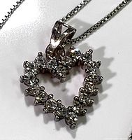 Close-up of the heart-shaped pendant with clear crystals on a sterling silver chain.