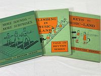 Three vintage music textbooks from 1941 with illustrated green covers, titled More Sounds More Surprises, Climbing in Music Land, and Keys to Music Land, all from the Tone and Rhythm Series.