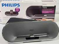 Philips Fidelio speaker in front of original box with product images and branding visible.