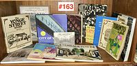 Photograph of 13 books focused on Toronto and local areas showing titles and covers spread on a wooden surface.