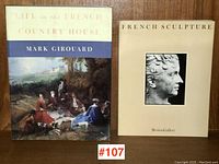 Two books side by side showing front covers: "Life in the French Country House" with a classic oil painting cover and "French Sculpture" with a beige cover and profile of a classical sculpture.