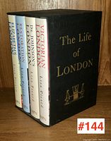 Four hardcover books in a black slipcase with gold lettering and illustration on the front.