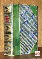 Full front cover of the book showing green half leather and marbled paper binding with gilt decoration on spine.