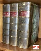 Three volumes of National Gazetteer Great Britain & Ireland on a wood shelf, showing spines with red labels and gold text.