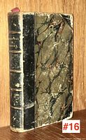 Full view of the front cover and spine of the black leather and marbled paper-bound book titled "Readings in Poetry" showing wear and tear.