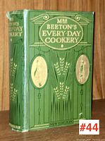 Front cover of the green hardcover book with gold embossed title 'Mrs. Beeton's Every-Day Cookery' and decorative motifs.