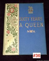 Front cover of the book showing the title 'Sixty Years A Queen' in gold embossed lettering on blue background, with floral and royal crest decoration on white spine and side panel.