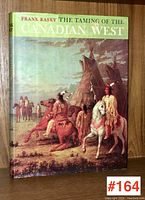 Front cover of 'The Taming of the Canadian West' showing painted historical scene with Indigenous riders and tipis.